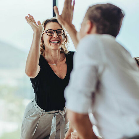 2 Mitarbeiter geben sich ein high-five – Teamwork ist alles